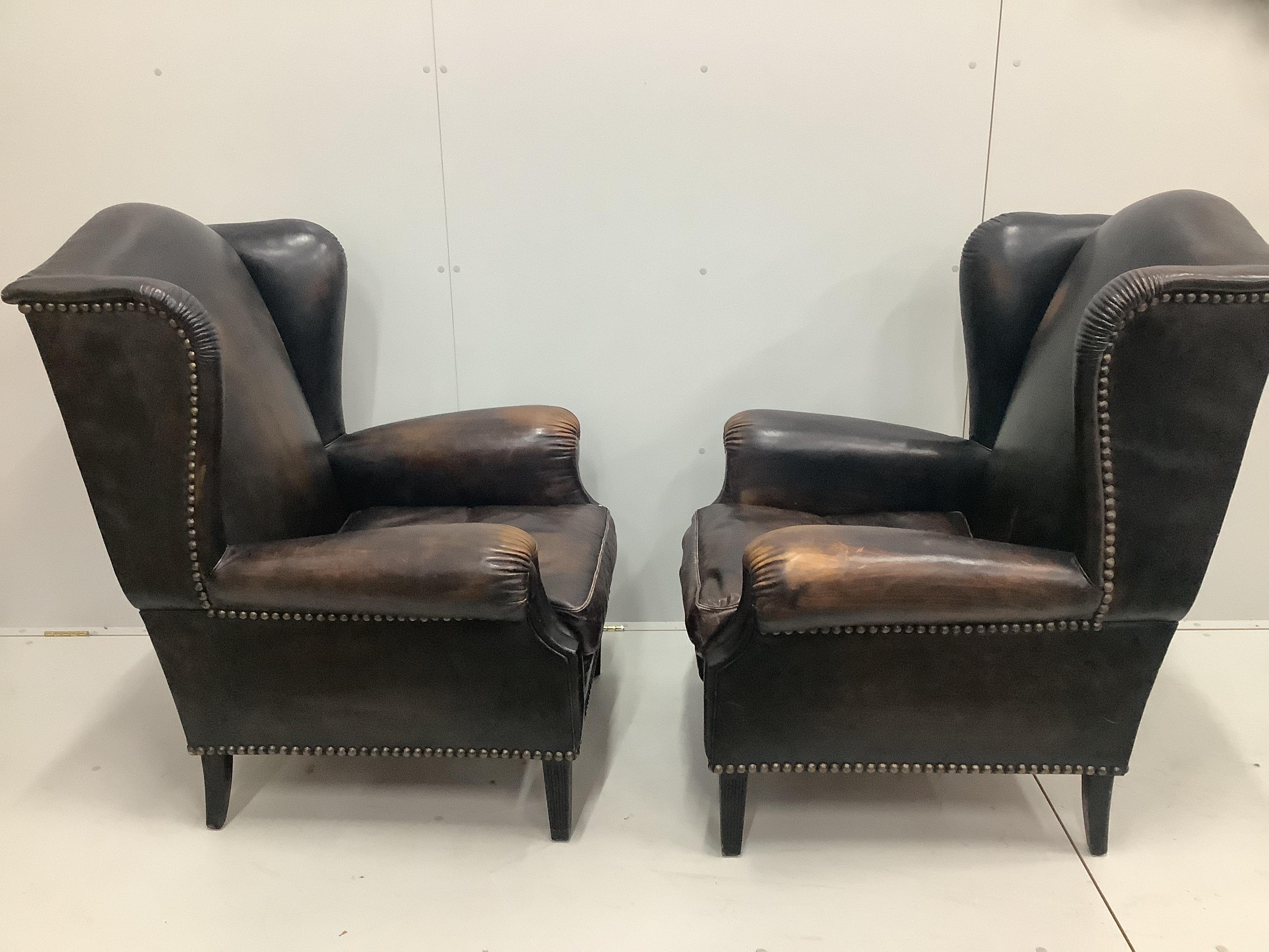 A pair of Victorian style brown leather wing armchairs, width 78cm, depth 88cm, height 106cm